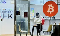 Một cô gái đứng trước quầy giao dịch tiền điện tử ở Hong Kong, Trung Quốc, ngày 22/1. (Ảnh: Reuters)