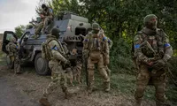 Lính Ukraine đứng gần chiếc xe quân sự ở khu vực gần biên giới Nga ngày 16/8. (Ảnh: Reuters)