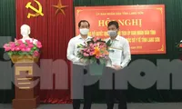 Ông Lý Kim Soi (bìa phải) nhận quyết định và hoa chúc mừng của lãnh đạo tỉnh Lạng Sơn .Ảnh: Duy Chiến