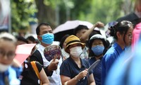 Bất chấp cái nắng gay gắt của Hà Nội, nhiều phụ huynh ngồi chầu chực ngoài cổng trường đợi con thi vào lớp 10. Ảnh: Đỗ Hợp