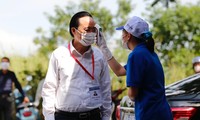 Bộ trưởng được lực lượng Y tế, tình nguyện viên đo nhiệt độ tại điểm thi.