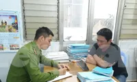 Cảnh sát lấy lời khai một trong số 10 đối tượng bị bắt. Ảnh CA