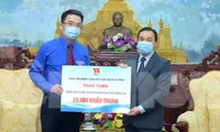 Anh Nguyễn Tường Lâm trao biển tặng 25.000 khẩu trang tới ông Seng Phết Hùng-Bun-Nhuông. Ảnh: Xuân Tùng