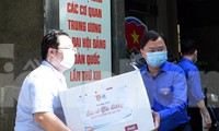 Anh Nguyễn Anh Tuấn và các đoàn viên thanh niên chuyển các thùng quà lên xe đến với các vùng dịch. Ảnh: Xuân Tùng