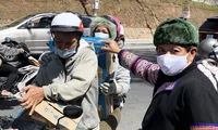 Ông Đoàn Ngọc Hải (bên phải) nhận các thùng sữa để chuyển lên vùng cao.