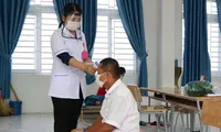 Nhân viên y tế đo thân nhiệt cho người dân cách ly tại Trung đoàn 896. Ảnh L.H