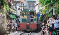 Du khách bất chấp nguy hiểm chụp ảnh tàu chạy qua khu cà phê đường tàu Ảnh: VOV