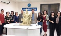 Đại sứ Nguyễn Phú Bình ( thứ 5 từ trái sang) trạo phiên bản tượng vua Hùng cho cộng đồng người Việt tại Ba Lan. Ảnh; TL