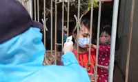 Nhân viên y tế đến từng nhà đo thân nhiệt cho người dân tại Mê Linh - Hà Nội. Ảnh: Mạnh Thắng