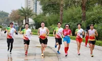 Chị Nguyệt Hằng (áo đỏ)- nhất cự ly half marathon 21km nhóm tuổi trên 45 tại Tiền Phong Marathon 2021