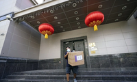 Nhân viên giao hàng ôm thùng carton bước ra khỏi lãnh sự quán hôm 23/7. Ảnh: AP