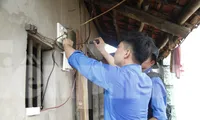 Sinh viên tình nguyện sửa điện giúp gia đình thương binh. Ảnh: Nguyễn Thắng