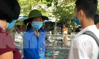 Thanh niên tienhf nguyện Thái Bình giúp thí sinh khử khuẩn trước khi vào phòng thi - Ảnh: Hoàng Long