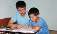 Em Lê Hữu Hiếu đang hướng dẫn em trai ôn tập hè.