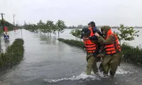 Lực lượng công an huyện Thạch Hà, tỉnh Hà Tĩnh sơ tán người già đến nơi an toàn. Ảnh: TP