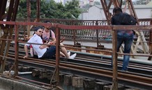 Du khách ngồi trên đường ray cầu Long Biên chụp ảnh