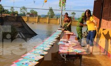 Lũ rút, giáo viên lội nước cao nửa mét vào trường mò tìm sách cho trò
