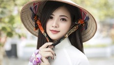Thiếu nữ xinh đẹp đội nón lá khoe sắc với hoa ban Thiếu nữ xinh đẹp đội nón lá khoe sắc với hoa ban