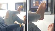 Người phụ nữ dùng chân vuốt màn hình tivi trên máy bay