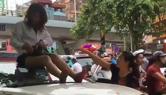 Nữ tài xế taxi mặc váy ngồi nóc ô tô chống đối CSGT
