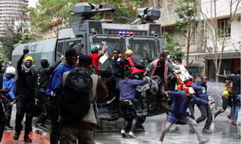 Người biểu tình Kenya cố cản trở xe của cảnh sát đến giải tán đám đông xông vào trụ sở quốc hội ngày 25/6. (Ảnh: Reuters)