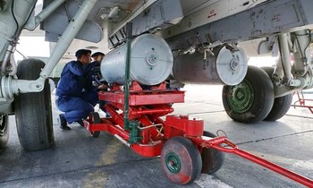 Các kinh nghiệm viên ko quân Nga đang được lắp đặt trái ngược bom lên giá bán treo bụng máy cất cánh cường kích Su-24 nhập cuộc cuộc luyện trận.