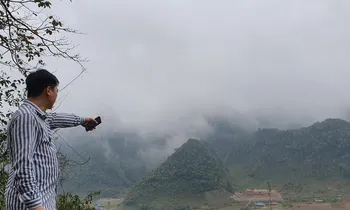 Thiếu tá Lường Văn Sơn đứng từ đỉnh dốc vào Hang Kia chỉ cho phóng viên khu nhà Vàng A Khua