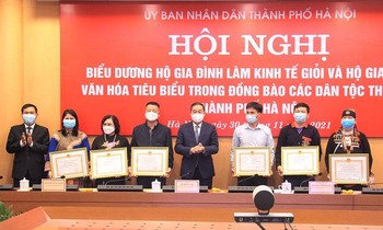 Ông Lê Hồng Sơn, Phó Chủ tịch Thường trực UBND TP. Hà Nội tặng Bằng khen của Chủ tịch UBND Thành phố cho các hộ gia đình tiêu biểu. Ảnh: TTXVN