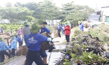 Các tình nguyện viên dọn rác, phát quang bụi rậm bên dòng kênh.