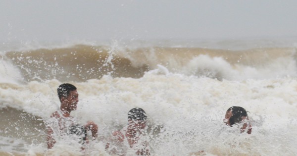 Bất chấp biển động, sóng to, người dân liều mình tắm biển sau bão