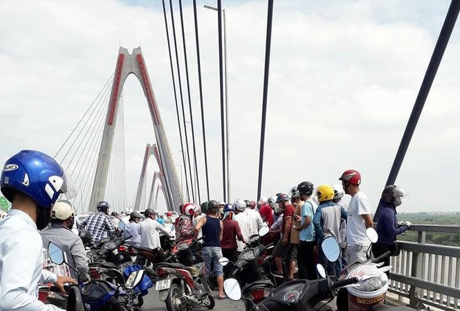 Nam thanh niên nhảy cầu Nhật Tân rồi tự bơi vào bờ Nhiều người dân hiếu kỳ dừng xe theo dõi sự việc.