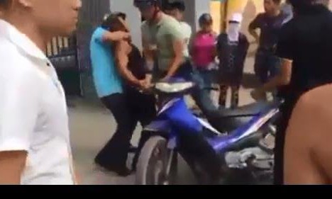 Vít cổ người vi phạm giao thông, một công an bị tạm đình chỉ? Người vi phạm bị người mặc thường phục (áo xanh) ghì cổ bẻ tay khống chế (ảnh cắt từ clip).