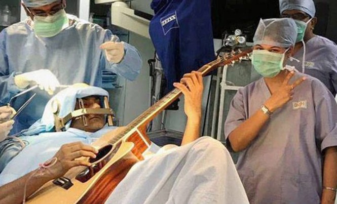 Vừa gảy đàn guitar vừa được mổ não Nhạc sĩ Abhishek Prasad gảy đàn trong khi các bác sĩ đang phẫu thuật cho ông. Ảnh: BBC.