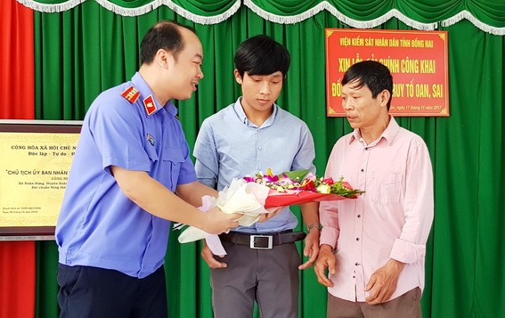 Người đàn ông bị truy tố oan sai được xin lỗi sau 10 năm kêu cứu Đại diện VKSND tỉnh Đồng Nai tặng hoa và xin lỗi ông Nguyễn Trần (bìa phải). Ảnh: baodongnai.com.vn