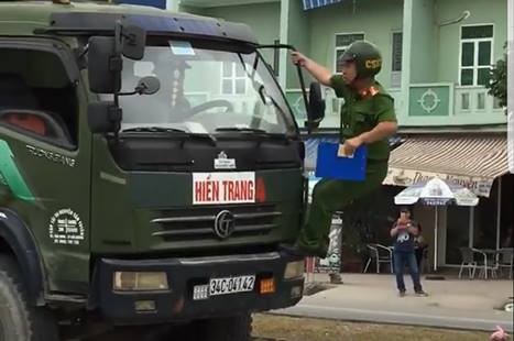 Tài xế cố tình cho xe chạy dù có cảnh sát đu bám trước đầu xe Tài xế vẫn điều khiển cho xe chạy mặc dù cảnh sát đang đu bám trước mũi xe (ảnh cắt từ clip)