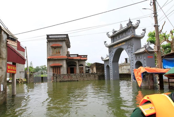 Chủ tịch Hà Nội: Sẵn sàng di dời 14.000 hộ dân nếu nước lũ lên cao Cổng thôn Nam Hài ngập sâu trong nước. Ảnh: Trường Phong