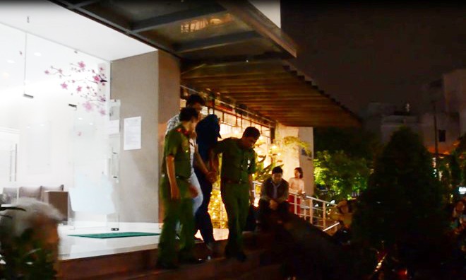 Vụ thi thể nữ sinh trong thùng xốp: Áp giải nghi phạm đến hiện trường Nghi phạm bị cảnh sát trùm kín mặt, còng tay đưa về trụ sở. Ảnh: Zing