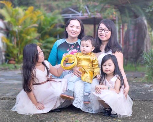 Cô giáo Quảng Ngãi đánh cược tính mạng để sinh con hộ chị gái Cô giáo Sang (váy trắng) hạnh phúc bên hai con gái của mình, chị gái và cậu bé Kem - con của chị gái anh rể, nhưng do cô sinh ra. Ảnh: NVCC