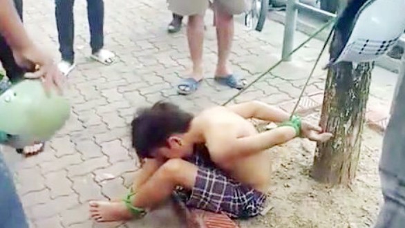 Tạm giữ 3 người trói thiếu niên đánh giày vì nghi trộm tiền Hình ảnh thiếu niên 16 tuổi bị trói vào gốc cây
