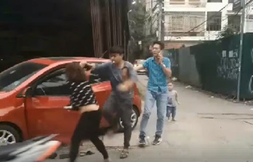 Chồng lên gối, đánh, đạp vợ dã man giữa đường trước mặt con nhỏ Người chồng hùng hổ lao vào đánh vợ bất chấp sự can ngăn của người đi đường. Ảnh cắt từ clip