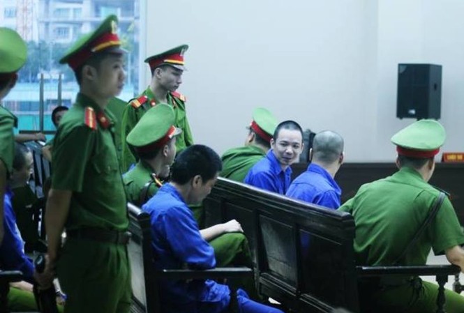 Tử tù vượt ngục hầu tòa trong vụ giấu 490 bánh heroin Nguyễn Văn Tình tươi cười tại tòa phúc thẩm.