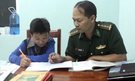 Chiến sỹ quân hàm xanh nâng bước em đến trường Đại uý Phạm Trần Duy - nhân viên Đội vận động quần chúng Đồn Biên phòng Xín Mần, Hà Giang kèm cháu Vàng Củi Vu. Ảnh: BTC