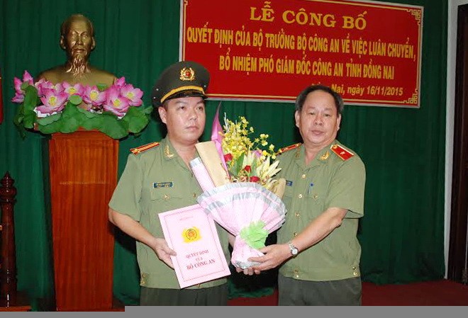 Con Chủ tịch TP.HCM làm Phó giám đốc Công an Đồng Nai Thiếu tướng Nguyễn Thanh Nam (bìa phải) trao quyết định và tặng hoa chúc mừng Trung tá Lê Hoàng Ngân. Ảnh: Báo Đồng Nai