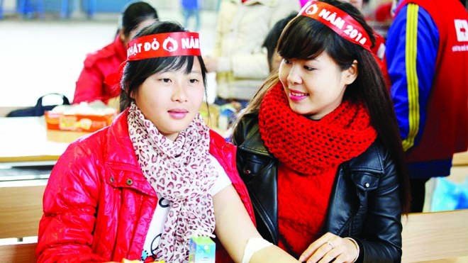 Tăng ghế tiếp nhận máu Người đẹp xứ Trà Phùng Thị Yến Hằng (phải) động viên các bạn sinh viên ĐH Nông Lâm Thái Nguyên sau buổi hiến máu chiều qua. Ảnh: trung hiền