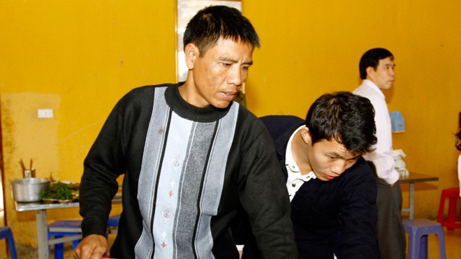 Thiếu tá làu 6 nội ngữ Anh Vương (ngoài cùng bên trái) chuẩn bị bữa cơm khi đồn có khách. ảnh: Xuân Tùng