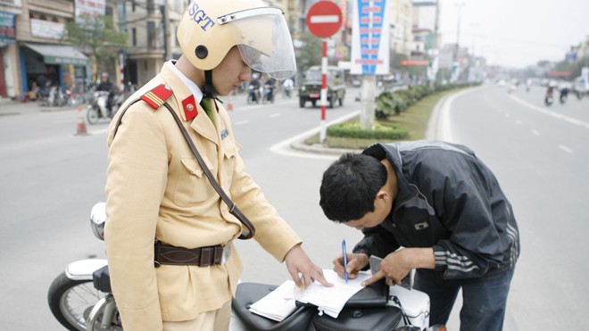 Đề xuất người vi phạm nộp phạt cho CSGT CSGT lập biên bản xử phạt chủ phương tiện vi phạm luật giao thông đường bộ ở Hà Nội. Ảnh: Hồng Vĩnh