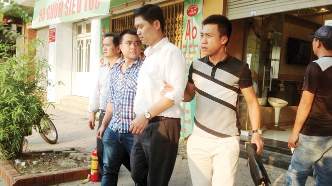 Vì sao vợ bác sỹ Tường không bị xử lý? Bác sỹ Tường (áo trắng) bị dẫn giải ra cầu Thanh Trì thực nghiệm điều tra. Ảnh: Lê Dương