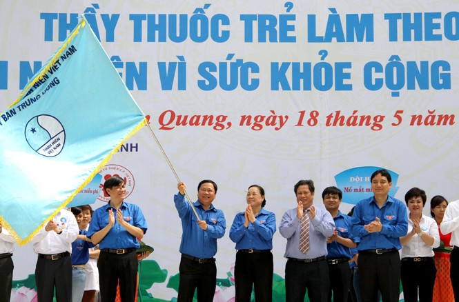 Thầy thuốc trẻ cả nước cứu chữa bệnh nhân nghèo Đồng chí Hà Thị Khiết và anh Nguyễn Đắc Vinh trao cờ xuất quân cho ban chỉ huy Ngày hội. ảnh: Mai Xuân Tùng