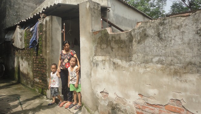 Mẹ tàn tật nuôi con thơ dại Chị Nhâm và hai con trước căn nhà xuống cấp. Ảnh: K.N
