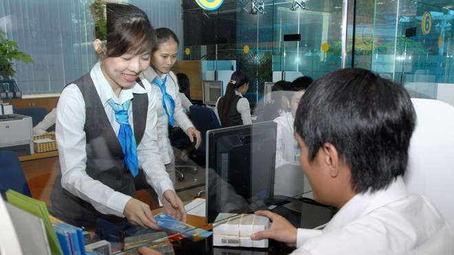 Ngân hàng đua nhau báo lãi: Thắng lớn nhờ cho vay cao? Khách háng đang làm thủ tục giao dịch vay tiền. Ảnh: Ngọc Châu